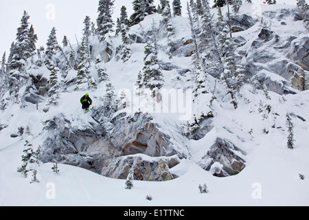 Ein männlicher Skifahrer fängt etwas Luft von einer Klippe in Revelstoke Mountain Resort, Revelstoke, BC Stockfoto