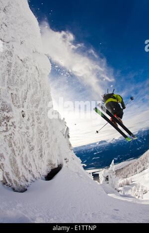 Ein männlicher Skifahrer fängt etwas Luft von einer Klippe in Revelstoke Mountain Resort, Revelstoke Backcountry, BC Stockfoto