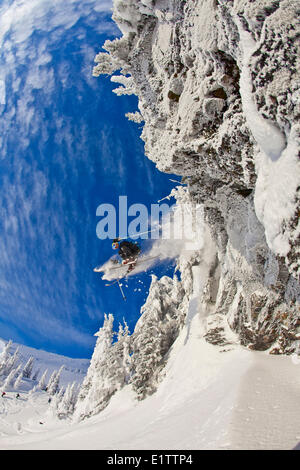 Ein männlicher Skifahrer fängt etwas Luft von einer Klippe in Revelstoke Mountain Resort Backcountry, Revelstoke, BC Stockfoto