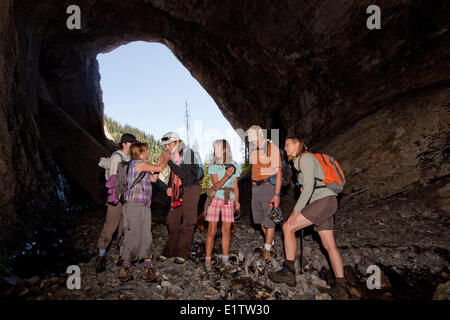 Zwei junge Familien entdecken Sie Höhle auf Mountain Lakes Trail in der Nähe von Fernie, BC, Kanada. Stockfoto