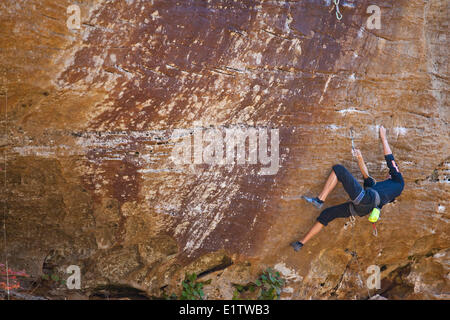 Ein männlicher Kletterer stellt Schutz und klettert Roggen knackig 5.8, City of Rocks, Idaho Stockfoto