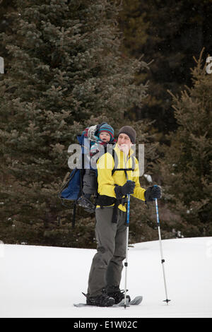 Ein Vater und ein neugeborener Junge gehen für eine Schneeschuhwanderung am Peter Lougheed Provincial Park, Kananaskis, AB Stockfoto