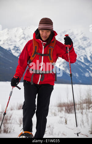 Eine junge Asiatin Schneeschuhwandern in der Nähe von Spray Seen, Kananaskis, AB Stockfoto