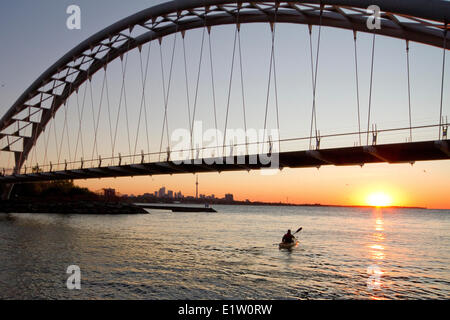 Junger Mann Kajak paddeln unter Humber River-Bogen-Brücke am Lake Ontario, Toronto, Ontario, Kanada. Stockfoto