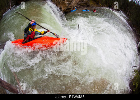 Eine männliche Kajakfahrer Fallenlassen eines Wasserfalls auf Johnston Canyon, Banff National Park, AB Stockfoto