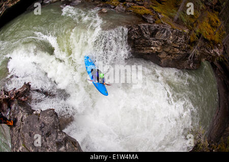 Eine männliche Kajakfahrer Fallenlassen eines Wasserfalls auf Johnston Canyon, Banff National Park, AB Stockfoto