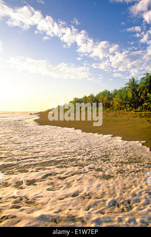 Wellen brechen sich am Strand bei Sonnenaufgang in der Nähe von Limon, Karibikküste Costa Rica Stockfoto