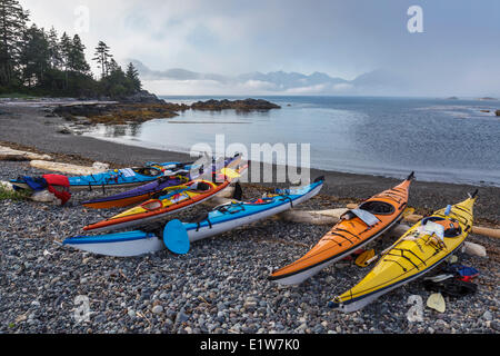 Kajaks sitzen oberhalb der Flut-Linie auf einer Insel im Nuchatlitz Provincial Park vor der Westküste von British Columbia, Kanada. Stockfoto