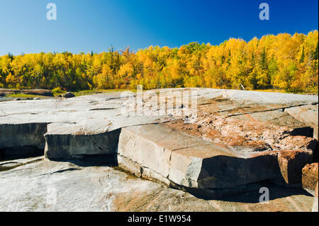 Präkambrischen Schild Felsen entlang des Winnipeg River mit Herbst Farben im Hintergrund, in der Nähe von sieben Schwestern, Manitoba, Kanada Stockfoto