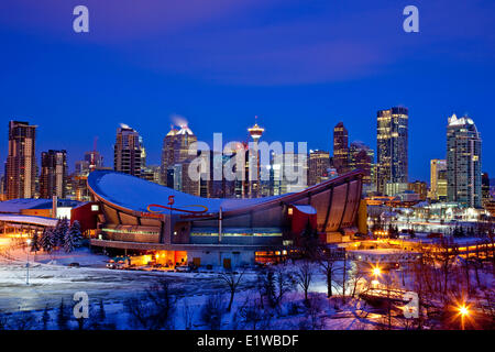 Skyline von Calgary in der Nacht im Winter mit Scotiabank Saddledome in Vordergrund, Calgary, Alberta, Kanada. Stockfoto