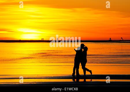Ein junges Paar küssen bei Sonnenuntergang entlang Chesterman Beach in der Nähe von Tofino, BC. Stockfoto