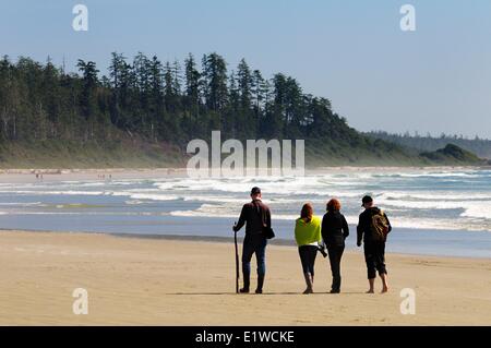 Vier Personen zu Fuß entlang der Long Beach im Pacific Rim National Park in der Nähe von Tofino, BC. Stockfoto