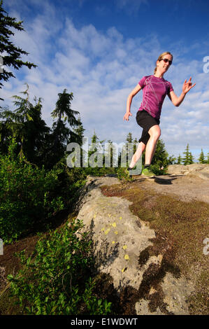Weibliche Trail-running-auf der Kabine Lake Trail am Black Mountain. Zypresse-provinzieller Park. West Vancouver British Columbia Kanada Stockfoto