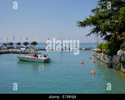 Motorboot mit Menschen verlassen kleinen Hafen, Gardasee, Sirmione, Italien Stockfoto