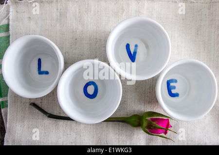 das Wort Liebe und rosa Rosen auf dem Tisch, von oben Stockfoto