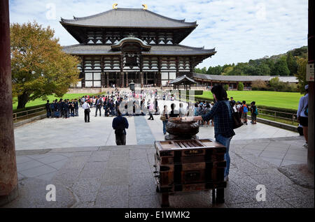 Ein Besucher neben stick eine Koro (Weihrauch-Brenner) Beleuchtung und Weihrauch an einer der historisch bedeutendsten Te Japans Stockfoto