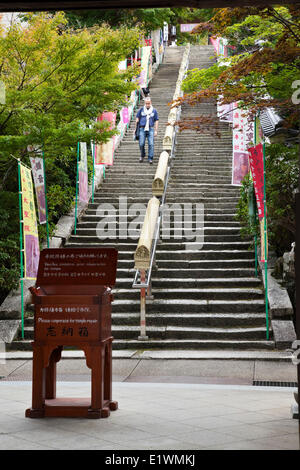 Gleich hinter der Eingang (Niomon) in den Tempel Daisho-in ist eine Treppe entlang der Gebetsmühlen mit Buddhi eingeschrieben sind Stockfoto