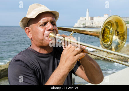 Posaune spielen Musiker auf dem Malecon, Morro Castle in Ferne, Havanna, Kuba Stockfoto