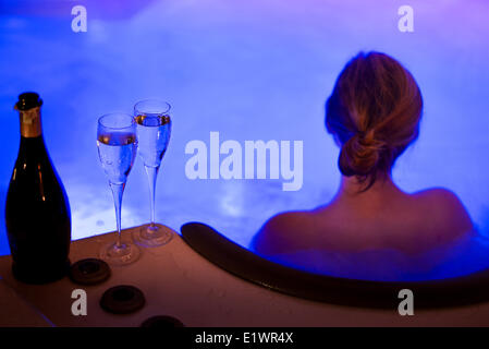 Attraktive Frauen im Whirlpool entspannen und trinken Champagner am Silvesterabend Stockfoto