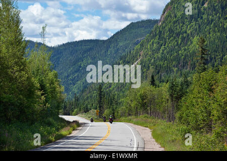 Motorradfahrer Touren auf einer Straße schneidet, die durch eine Bergkette im Parc national des Grands-Jardins, Charlevoix, Quebec, Canad Stockfoto