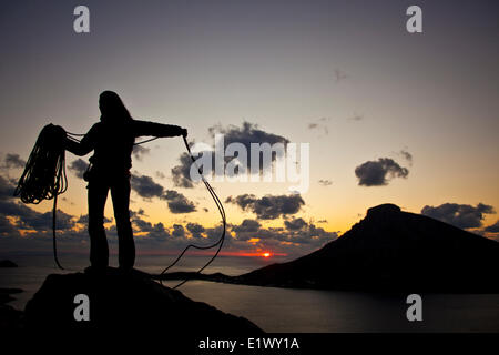 Eine junge Frau Aufwickeln des Seils nach einem Tag des Kletterns in Kalymnos, Griechenland Stockfoto