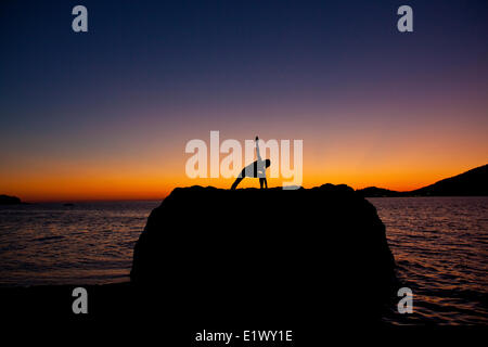 eine junge Frau, Yoga zu praktizieren, bei Sonnenuntergang. Kalymnos, Griechenland Stockfoto
