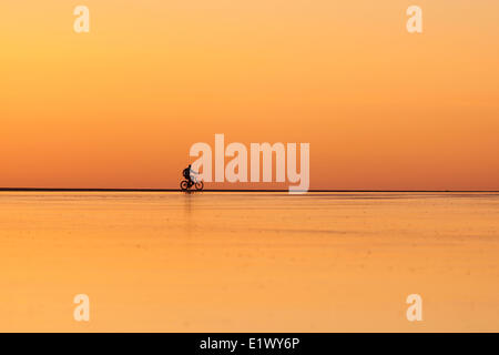 Eine einsame Person Reiten einen Beach Cruiser Chesterman Strand entlang bei Ebbe Heads nach Hause nach Sonnenuntergang.  Chesterman Beach Tofino Stockfoto