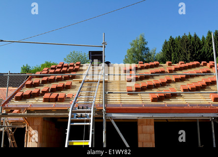 Ein Dach im Bau mit Stapeln von Dachziegeln Stockfoto