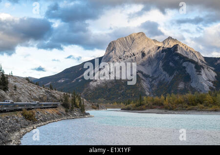 Personenzug entlang des Athabasca River und Roche Miette bei Sonnenuntergang in den Rocky Mountains, Alberta, Kanada. Stockfoto