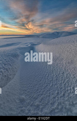Sonnenuntergang farbige Wolken über den schneebedeckten Tundra und hängen des Crow Mountain, Old Crow, Yukon. Stockfoto
