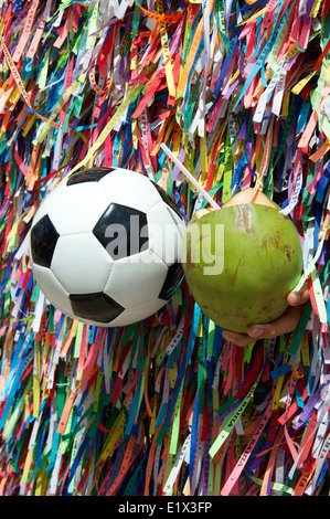 Brasilianische Kultur mit Fußball Fußball und frische grüne Coco Gelado Kokosnuss an Wand des Wunsch-Bänder in Salvador Bahia Brasilien Stockfoto