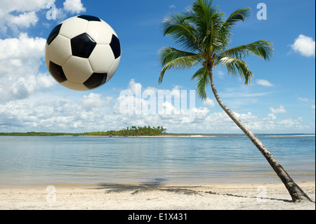 Fußball Ball fliegen in den Himmel über tropischen hellen brasilianischen Strand in Nordeste Bahia Brasilien Stockfoto