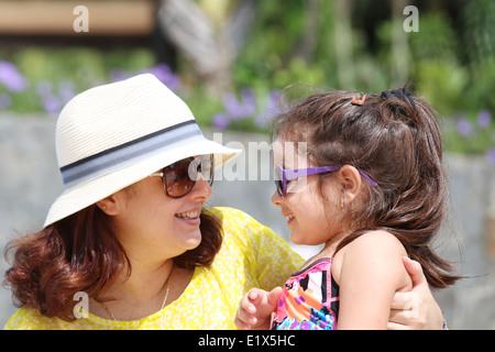 Porträt von Mutter und Tochter im Freien suchen einander in Sumertime. Das kleine Mädchen im Fokus Stockfoto