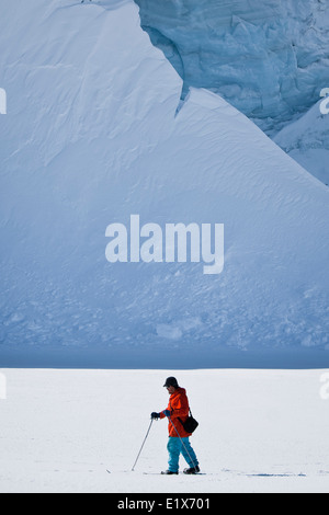 Mann geht auf Skiern. Gletscher im Hintergrund. Antarktis Stockfoto