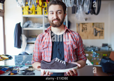 Porträt von ein gut aussehender Mann, der Verkauf von Schuhen im Sportgeschäft Stockfoto