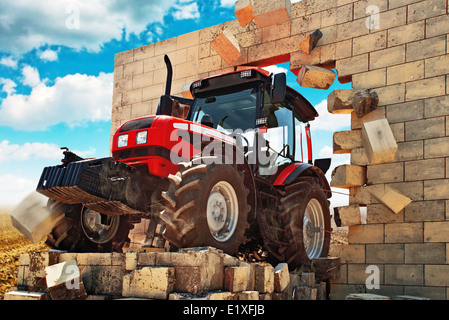 Brandneue Traktor, leistungsfähigen landwirtschaftlichen Arbeitsmaschine Wand durchbrechen. Überwinden alle Hindernisse in der Landwirtschaft. Stockfoto