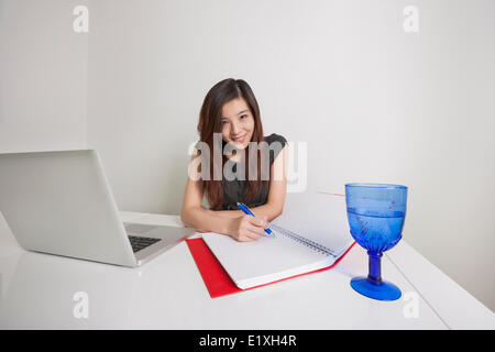 Porträt von überzeugt junge Geschäftsfrau schreiben Tagebuch am Schreibtisch Stockfoto