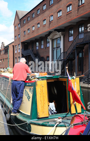 Man arbeitet an einem Narrowboat im Gas Street Canal Basin, Birmingham, West Midlands, England, UK, Westeuropa. Stockfoto