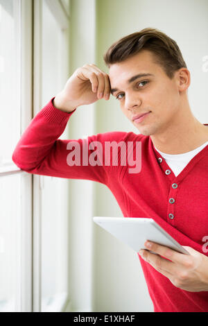 Porträt von zuversichtlich junger Geschäftsmann mit Tablet-PC im Büro Stockfoto