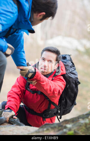 Männliche Wanderer Freund helfen, beim Wandern im Wald Stockfoto