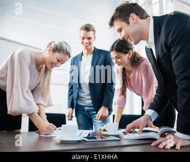 Glückliche junge Geschäftsleute brainstorming am Konferenztisch Stockfoto