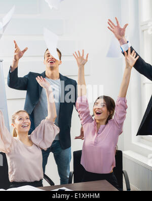 Geschäftsleute, die Papiere zu werfen, in der Luft im Büro Stockfoto