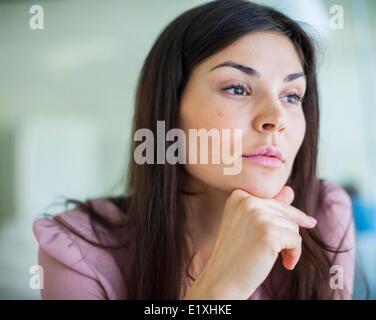 Nachdenkliche junge Geschäftsfrau wegschauen im Büro Stockfoto