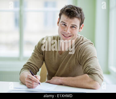 Porträt der schönen Geschäftsmann auf Dokument am Schreibtisch im Büro schreiben Stockfoto