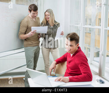 Geschäftsmann mit Laptop beim Kollegen diskutieren über Dokumente in office Stockfoto