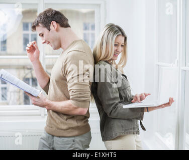Glückliche Unternehmen paar hält Buch und Laptop im Büro Stockfoto
