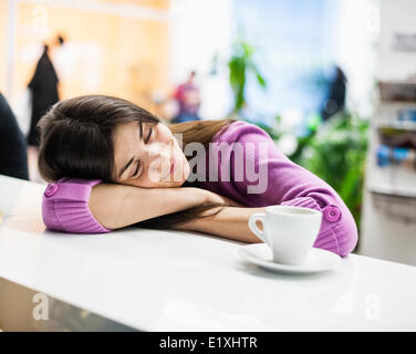 Junge Geschäftsfrau schlafen am Schreibtisch im Büro Stockfoto