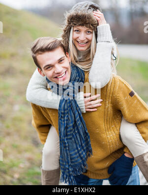 Porträt von glücklichen Menschen Huckepack Frau im park Stockfoto