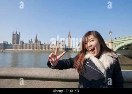 Porträt der jungen Frau gestikulieren schlägt gegen Big Ben in London, England, UK Stockfoto