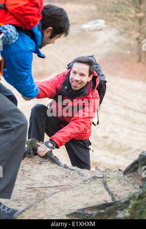 Wanderer, die helfen, Freund beim Wandern im Wald Stockfoto